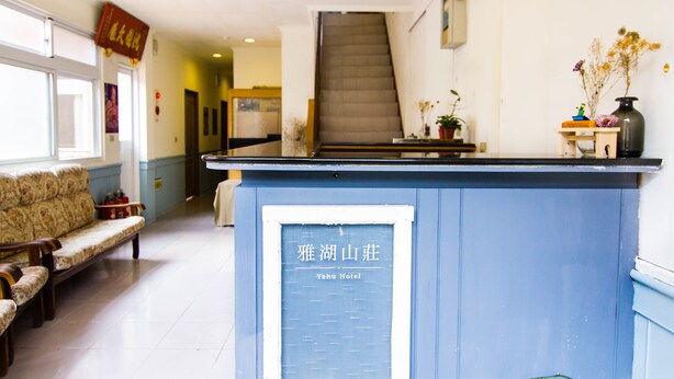 A reception desk with a sign reading "Yahuh Hotel". - Yahu Hotel (Zhuqi)