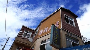 Um edifício com uma placa que diz "Hotel" e outra com caracteres chineses.
