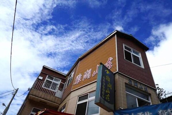 A building with a sign that reads "Hotel" and another sign with Chinese characters. - Yahu Hotel (Zhuqi)