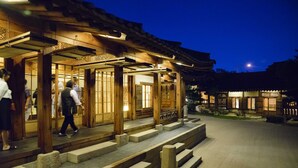 Un edificio japonés tradicional con arquitectura de madera y un sendero de piedra que conduce a la entrada.