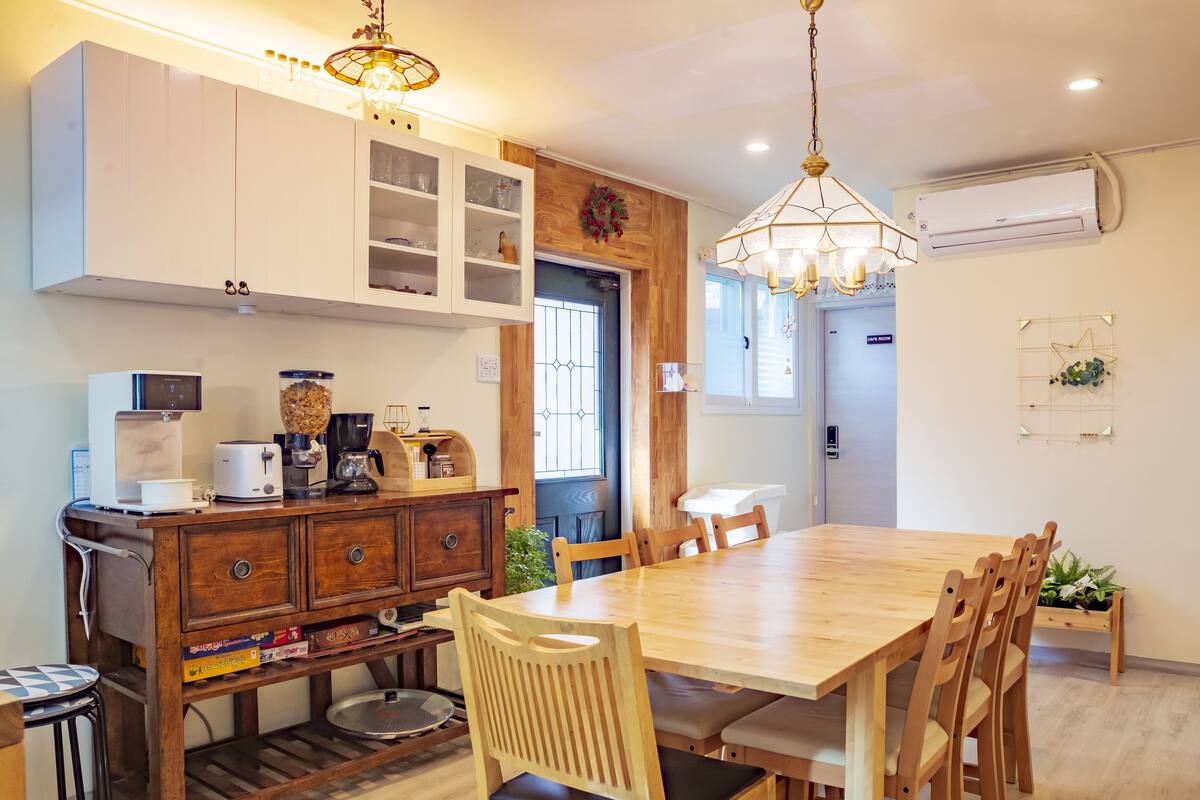 Uma cozinha moderna com mesa de jantar de madeira, armários embutidos e uma máquina de café.