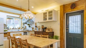Una cocina moderna con armarios de madera, una isla central y un comedor con mesa y sillas de madera.