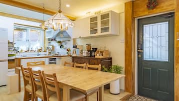 A modern kitchen with wooden cabinets, a central island, and a dining area with a wooden table and chairs.