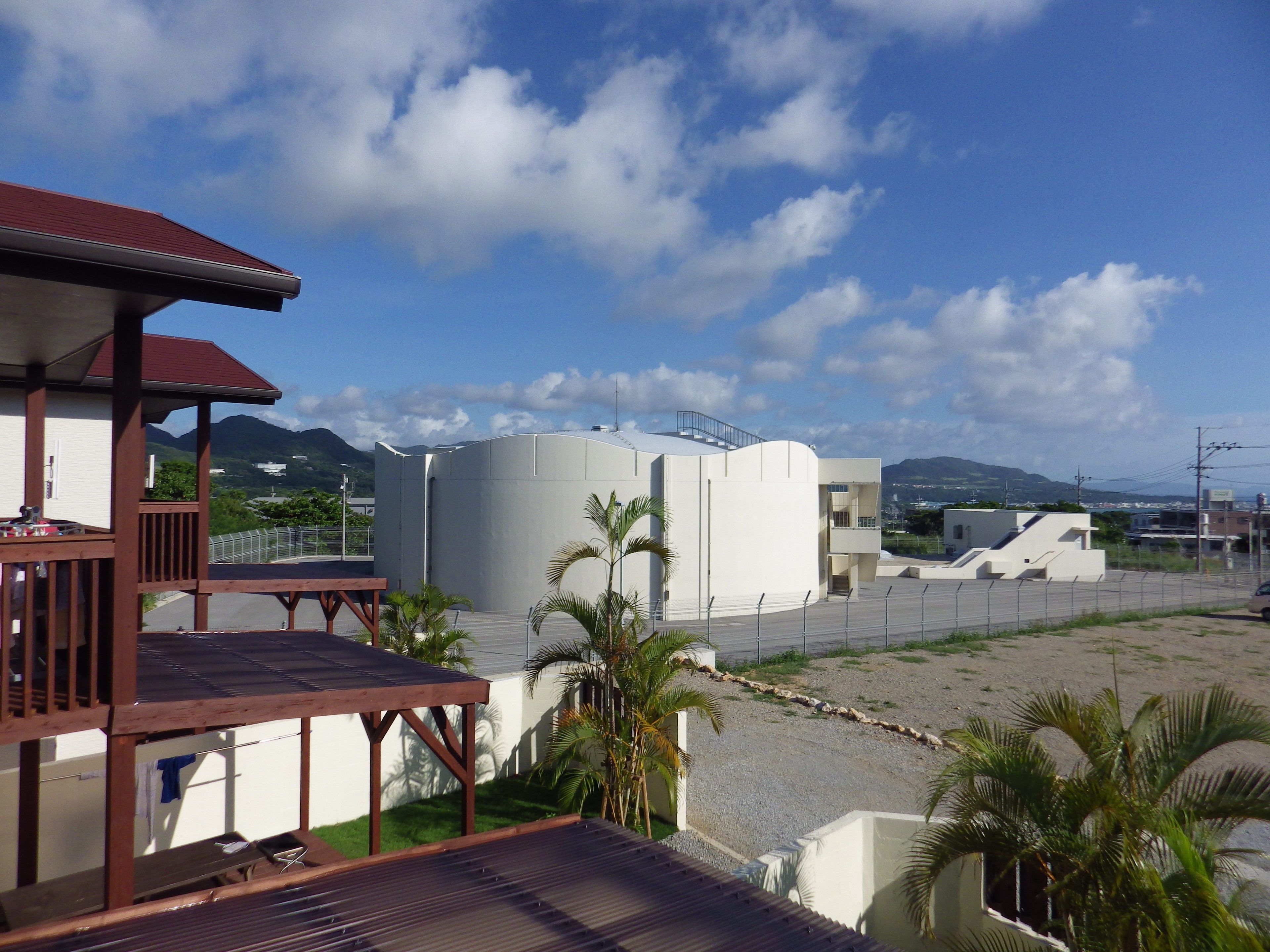 A building with a wooden deck and a view of mountains and a clear sky.