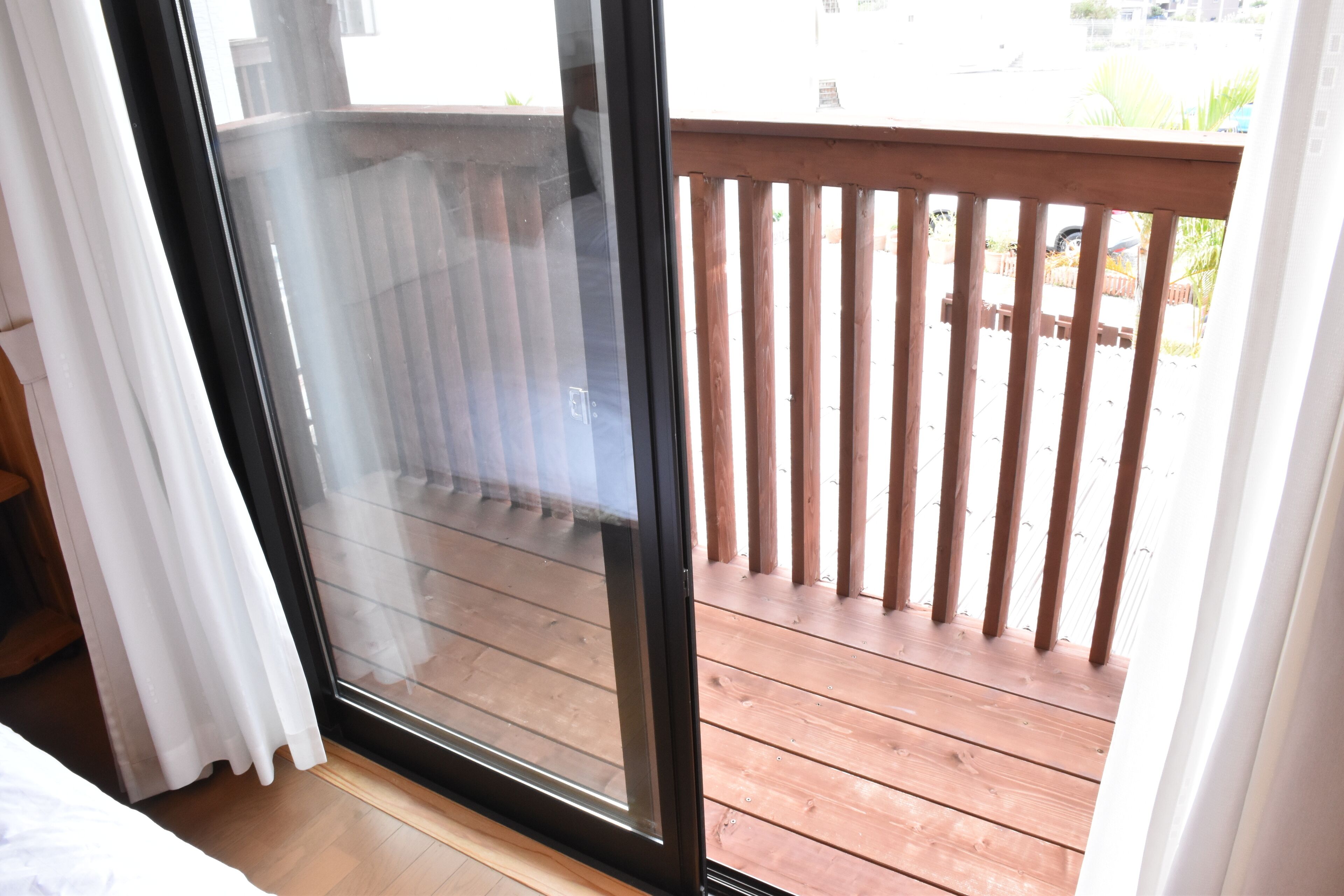 A room with a sliding glass door leading to an outdoor wooden deck.