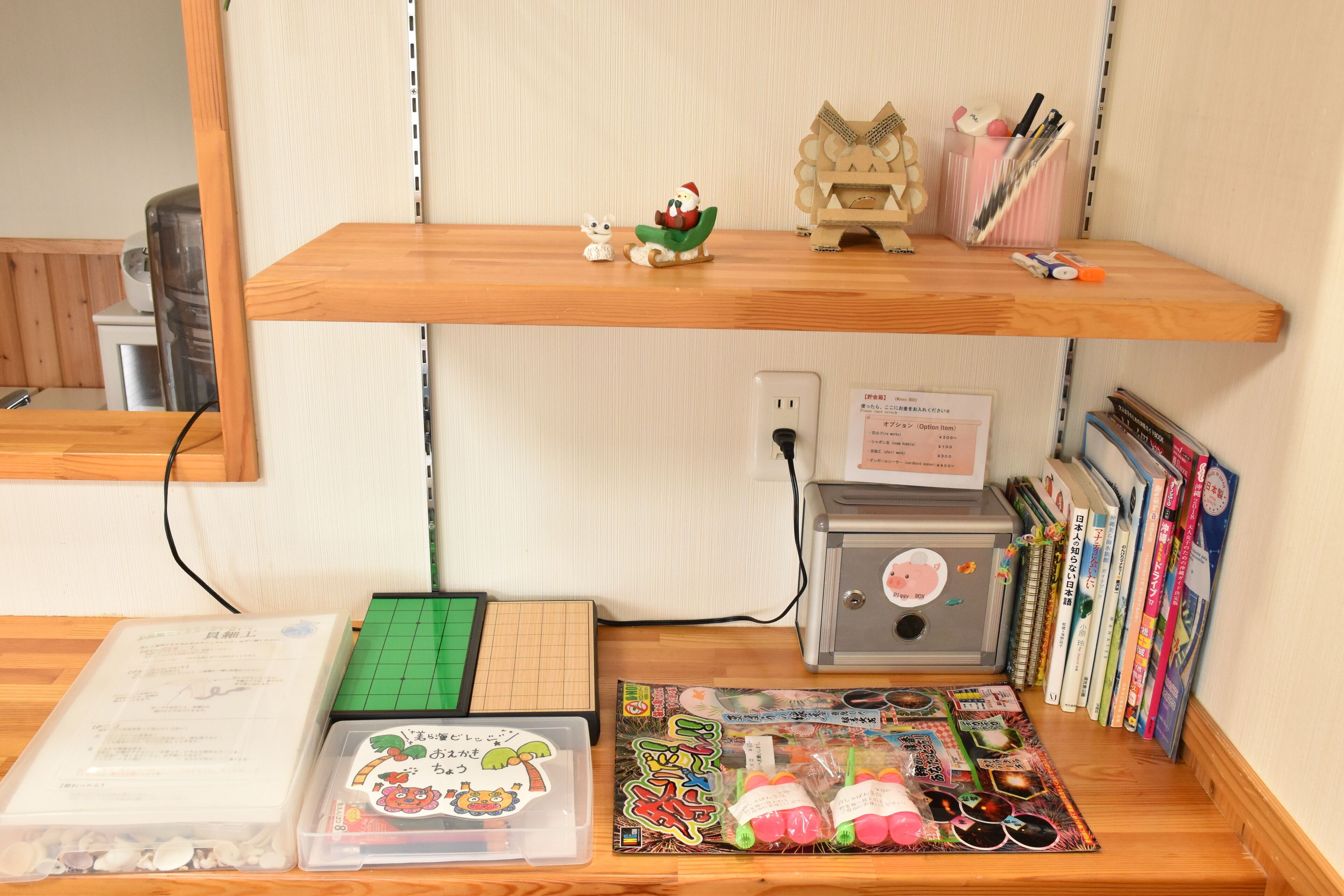 A workspace with a wooden desk, a computer, a printer, and shelves with books and decorative items.