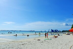 On the beach, white sand, beach towels, motor boating