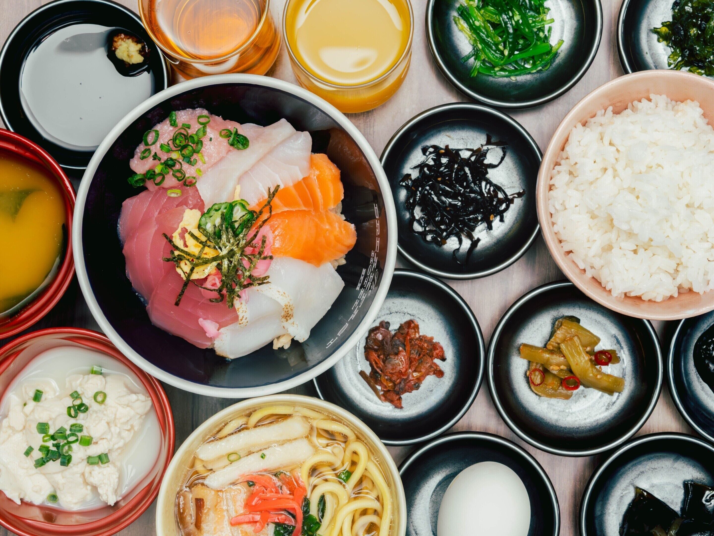 A variety of Japanese dishes including sashimi, rice, and soup.
