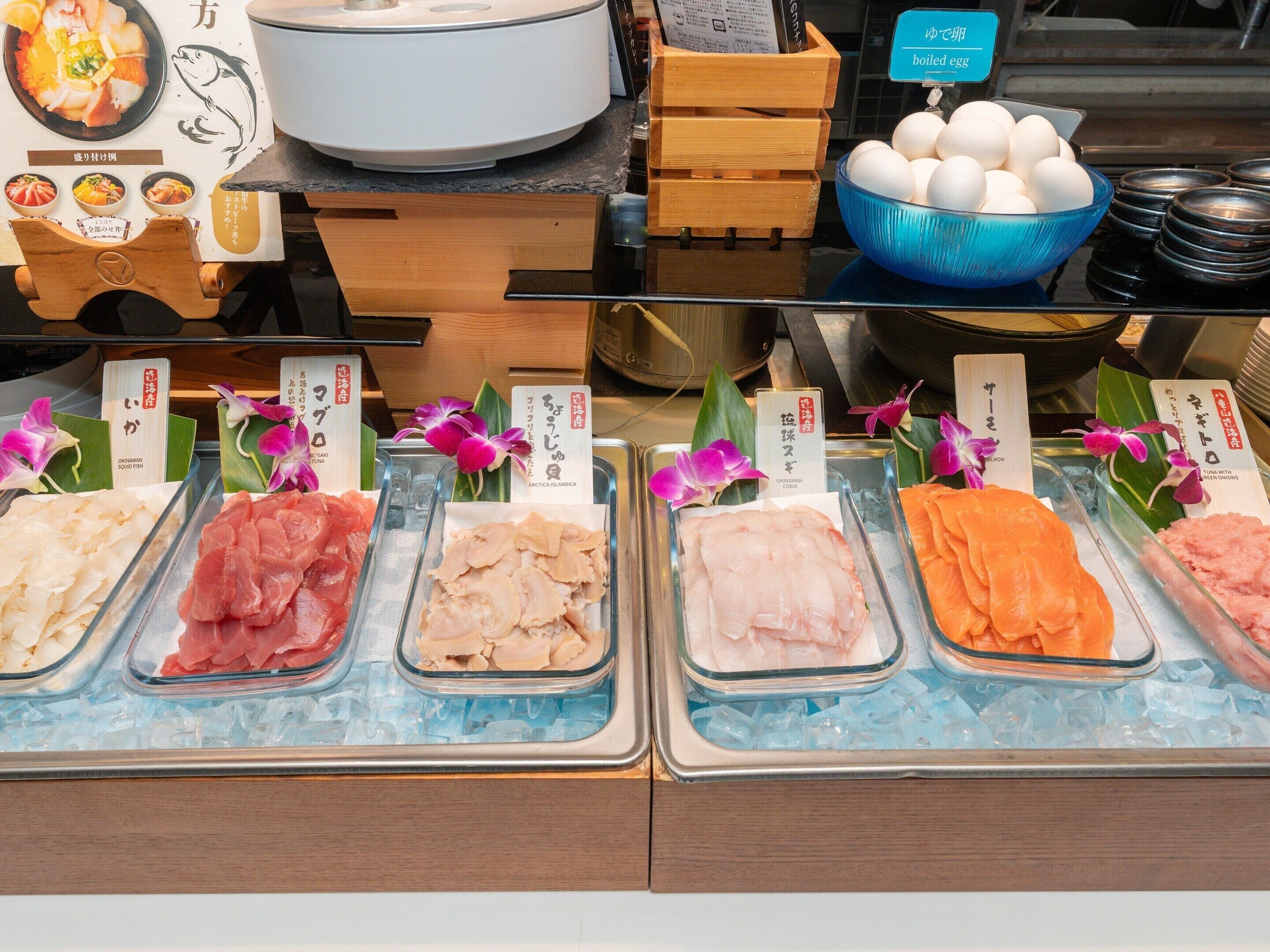 A seafood display with various types of fish and a bowl of eggs.