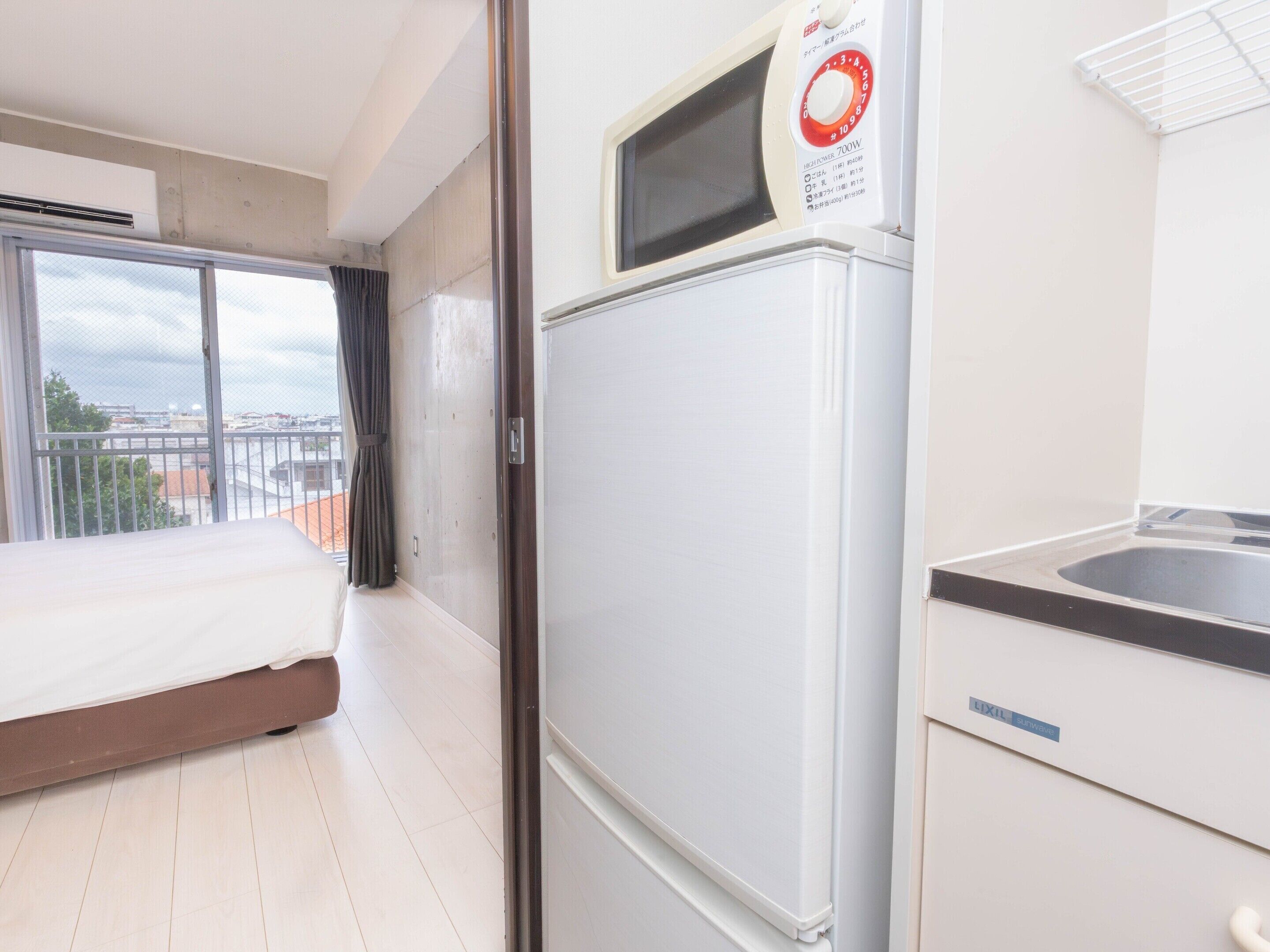 Ein Hotelzimmer mit einem Bett, einem Kühlschrank, einer Mikrowelle und einem Waschbecken.