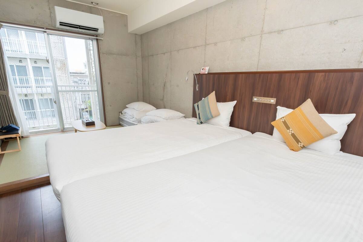 A hotel room with a large bed, a wooden headboard, a window with a view, and a small table.