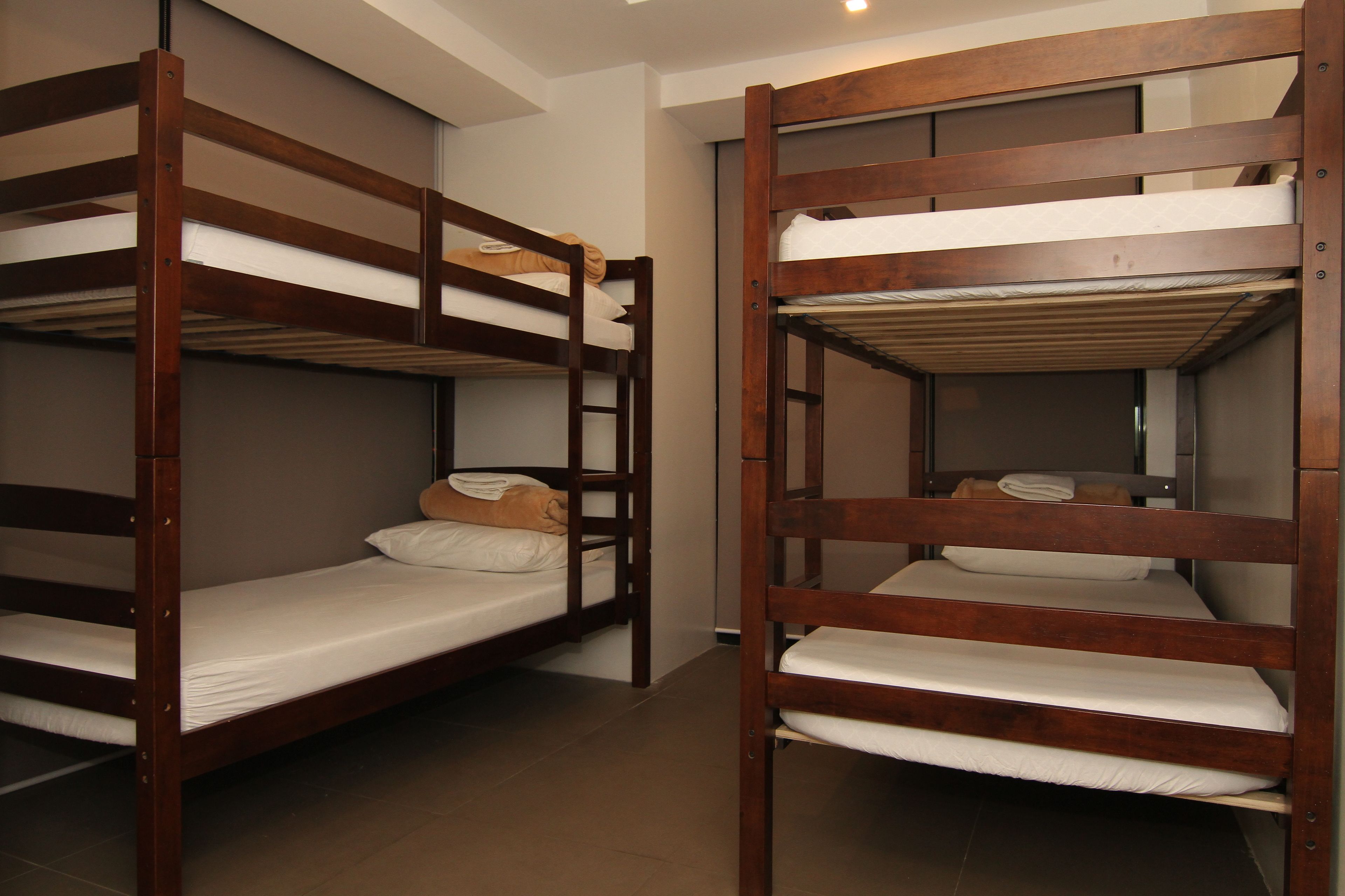 Une chambre avec deux lits superposés, chacun étant équipé d’un matelas et d’oreillers.