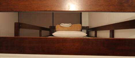 A bed with a wooden headboard and a white mattress.