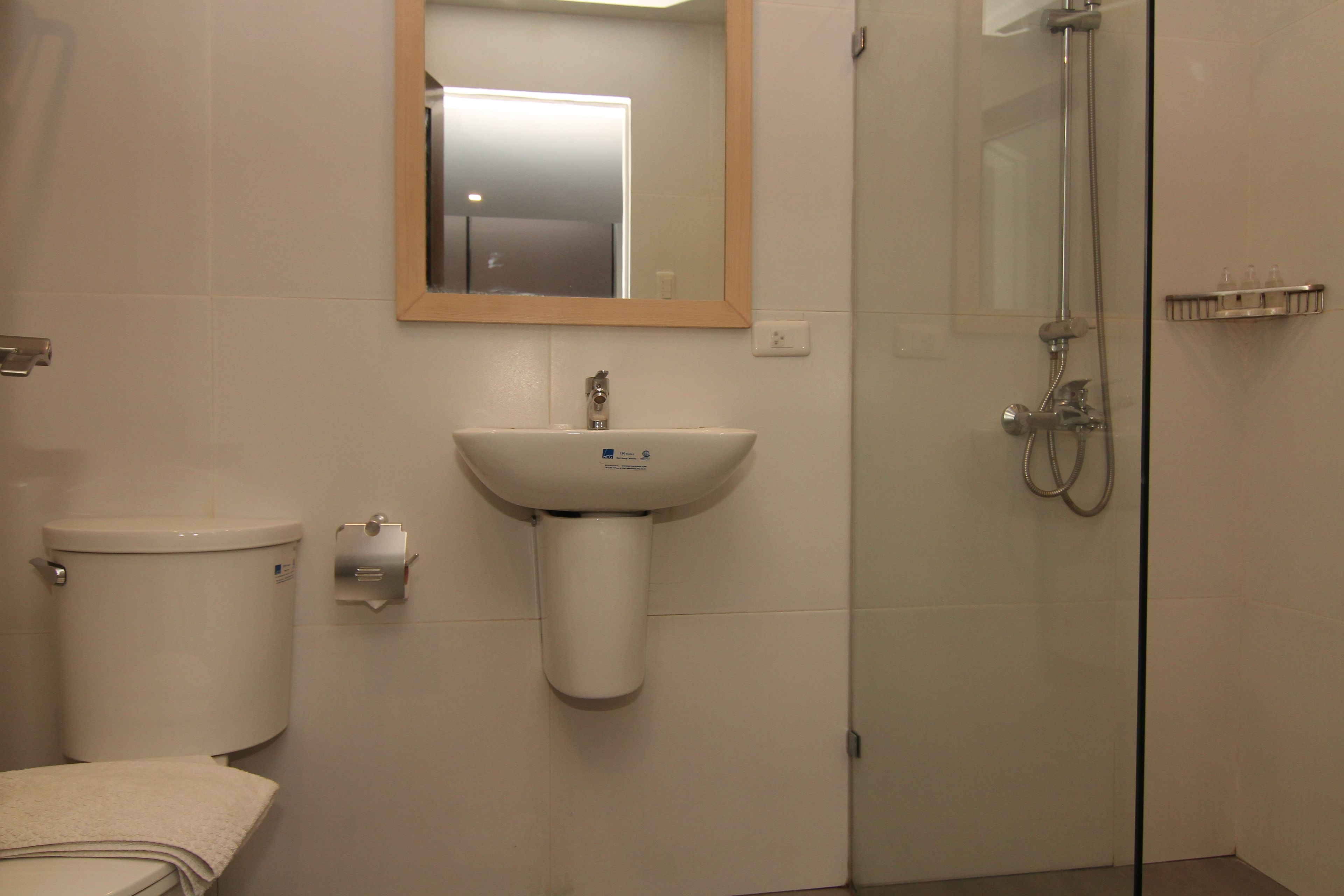 A bathroom with a toilet, sink, and shower.