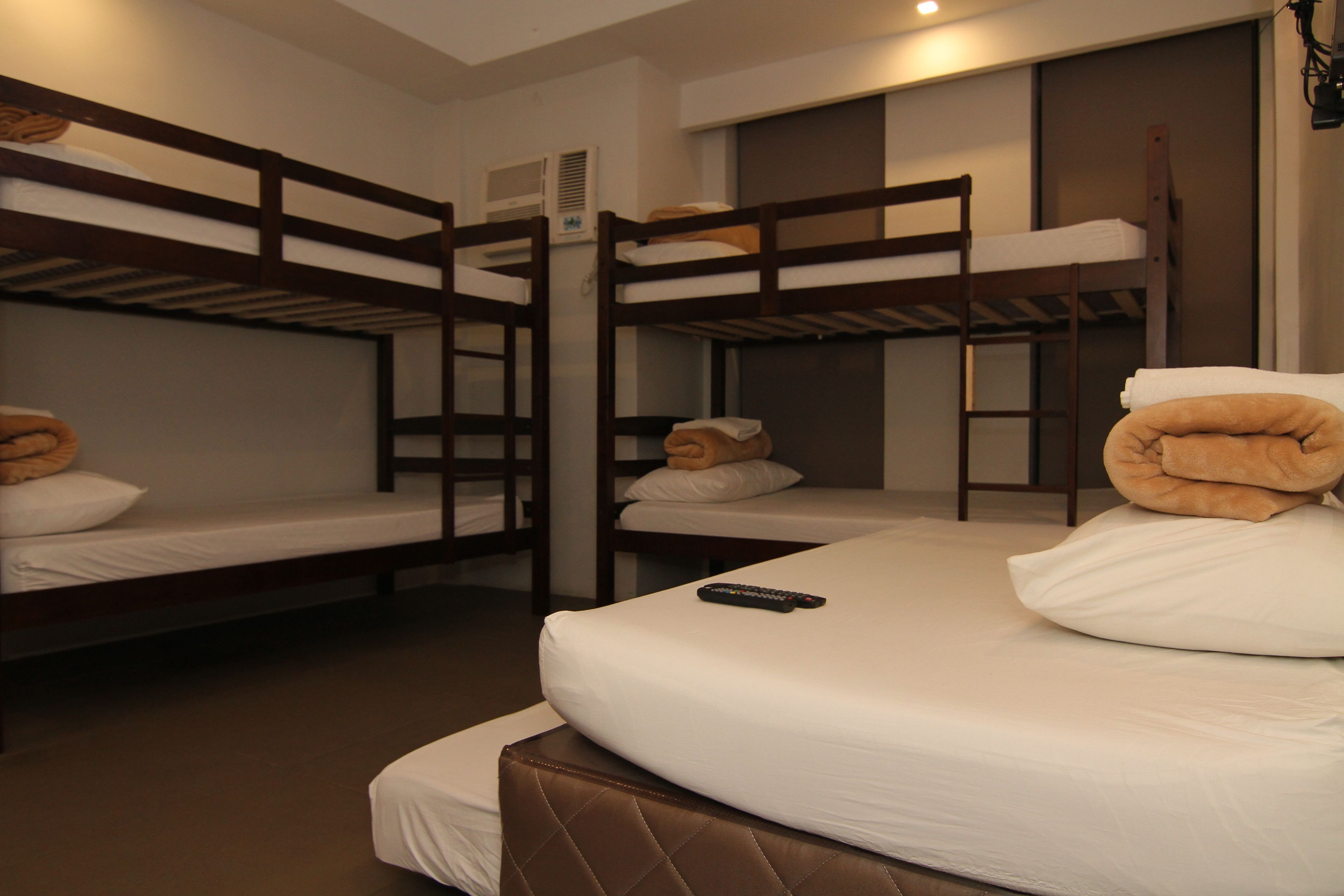 A bunk bed room with a remote control on the top bunk.