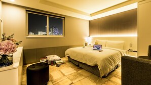 A modern hotel room with a large bed, a desk with a laptop, a nightstand, and a window with a city view. - Sleep with Your Own Pet Only - The Petel (Busan)