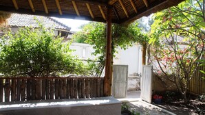 A covered outdoor seating area with a wooden bench and a concrete table. - Beach Camp (Gili Trawangan)