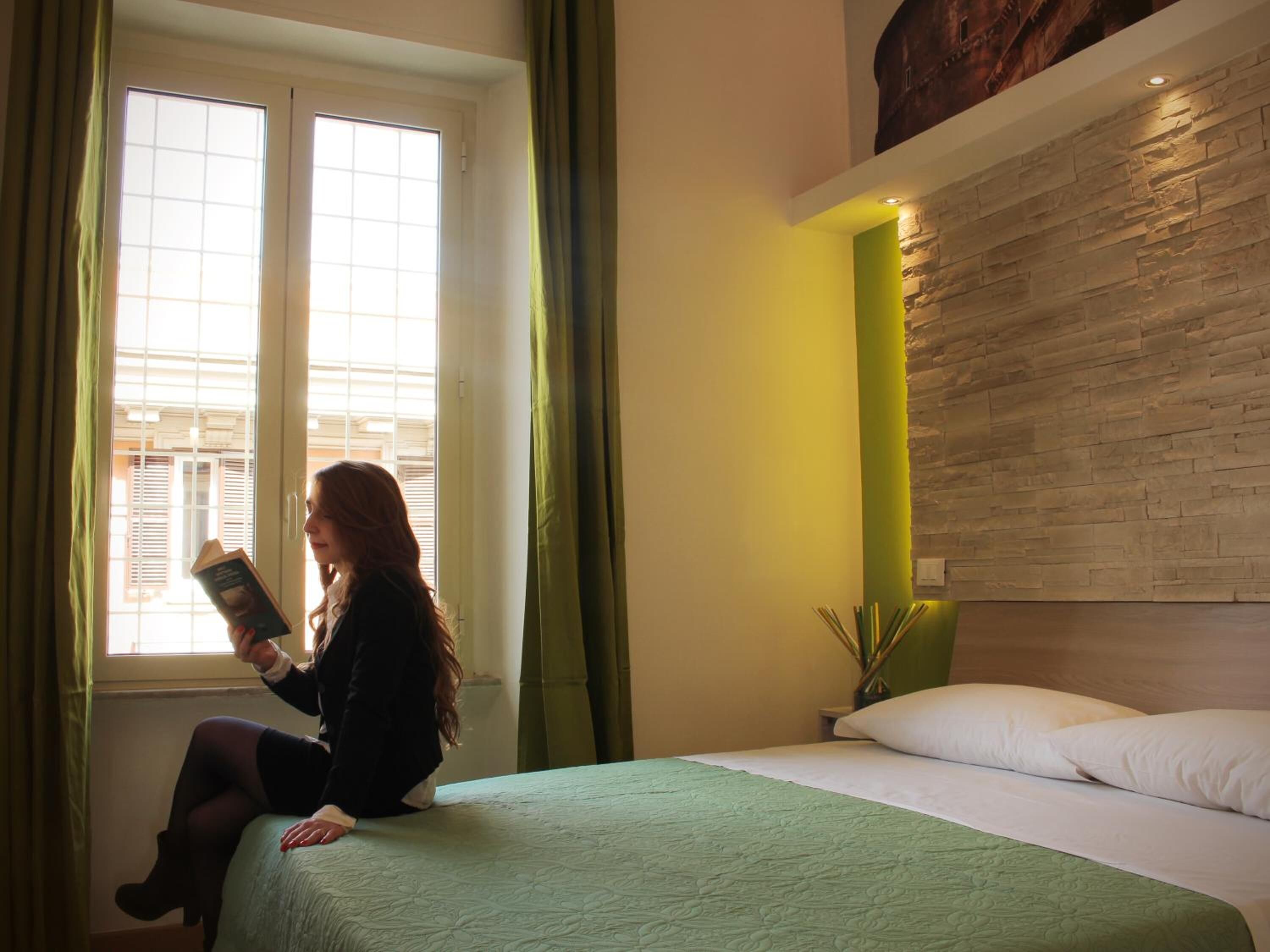 Een kamer met een bed, een raam met gordijnen en een wand met een structuur.