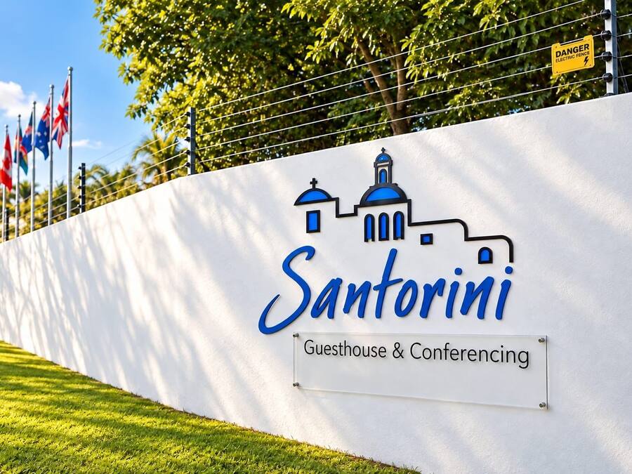 A wall with a logo and text indicating 'Santorini Guesthouse & Conferencing'.