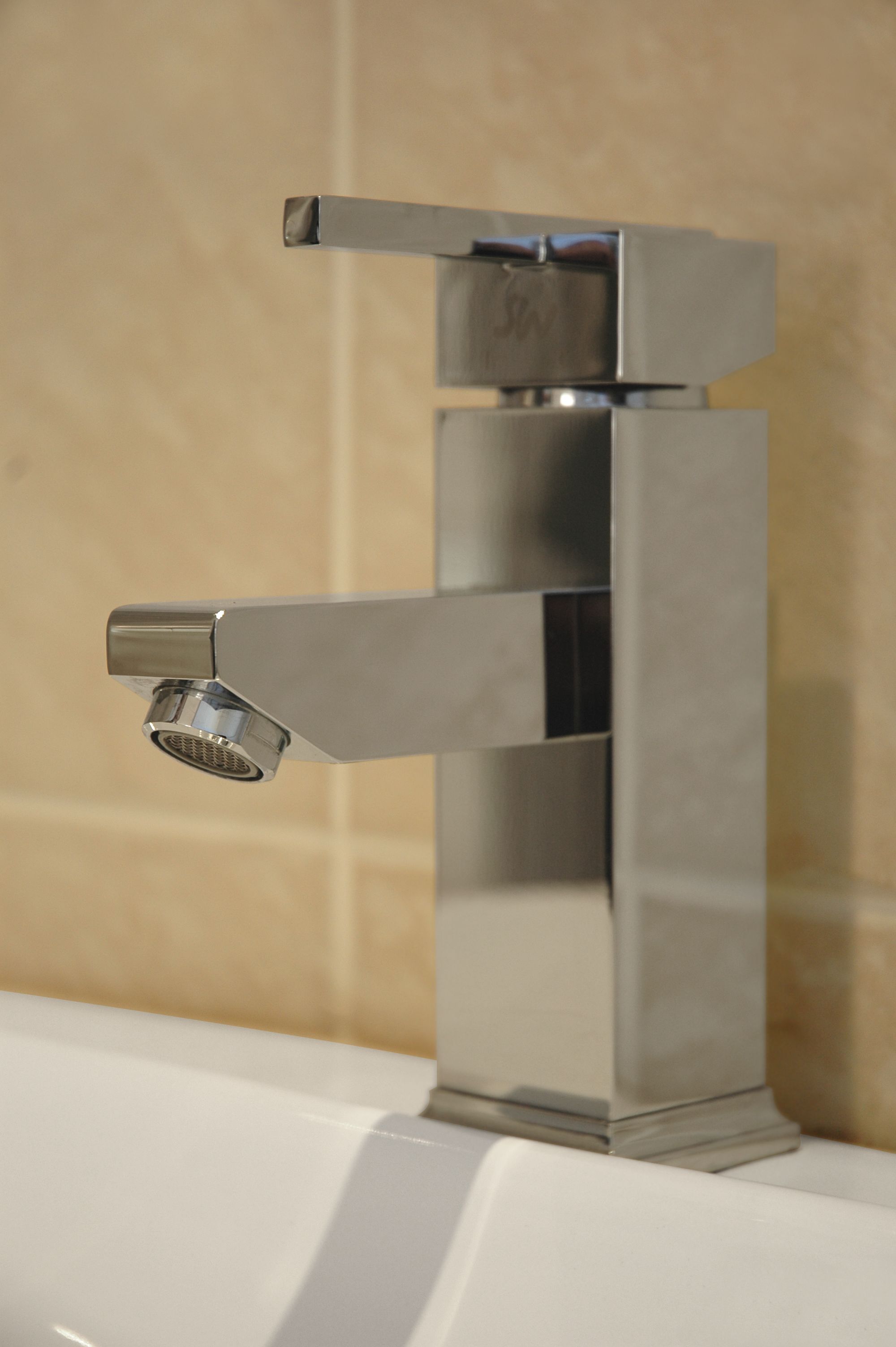 Un bagno moderno con un rubinetto cromato e un lavandino bianco.