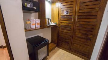 Una kitchenette compacta equipada con microondas, un refrigerador pequeño y una cafetera.