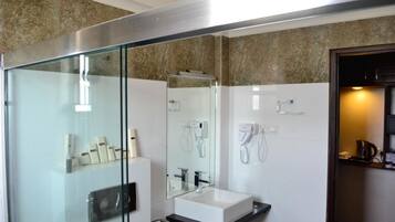 Une salle de bain moderne avec une douche à parois de verre, un lavabo blanc et un miroir au-dessus.