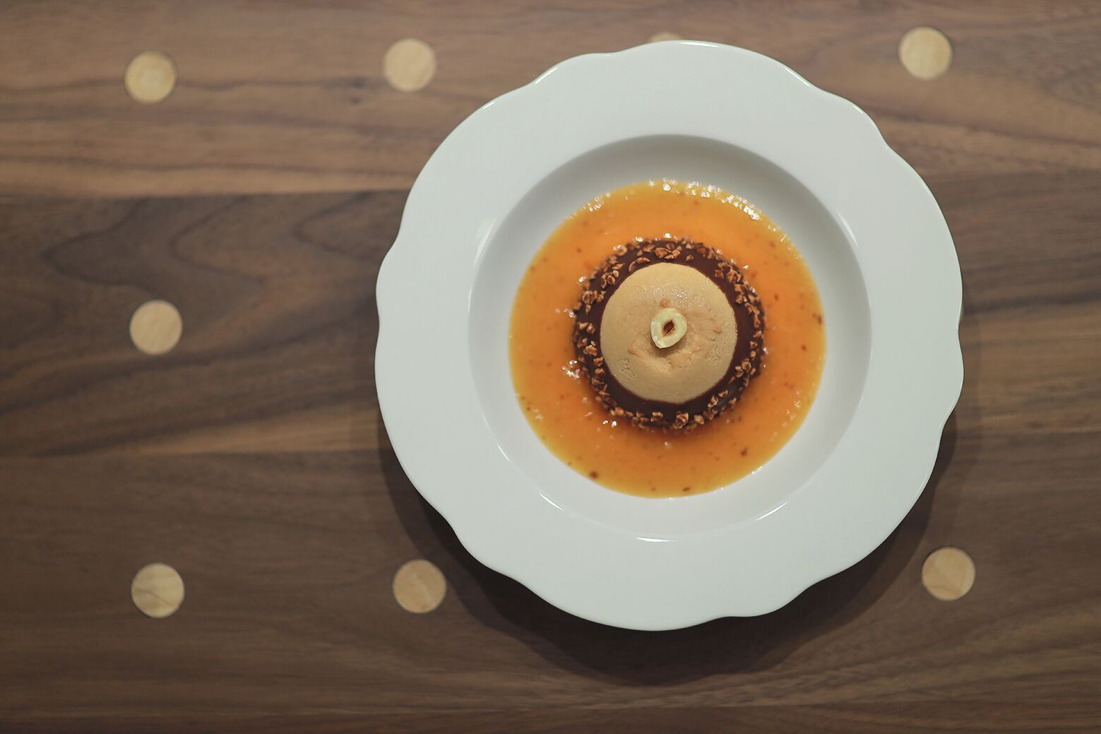 A white plate with a dessert on a wooden table.