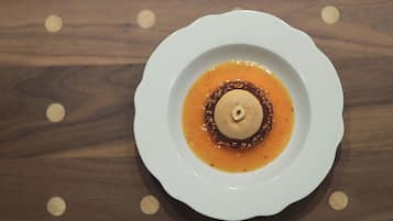 A white plate with a dessert on a wooden table.
