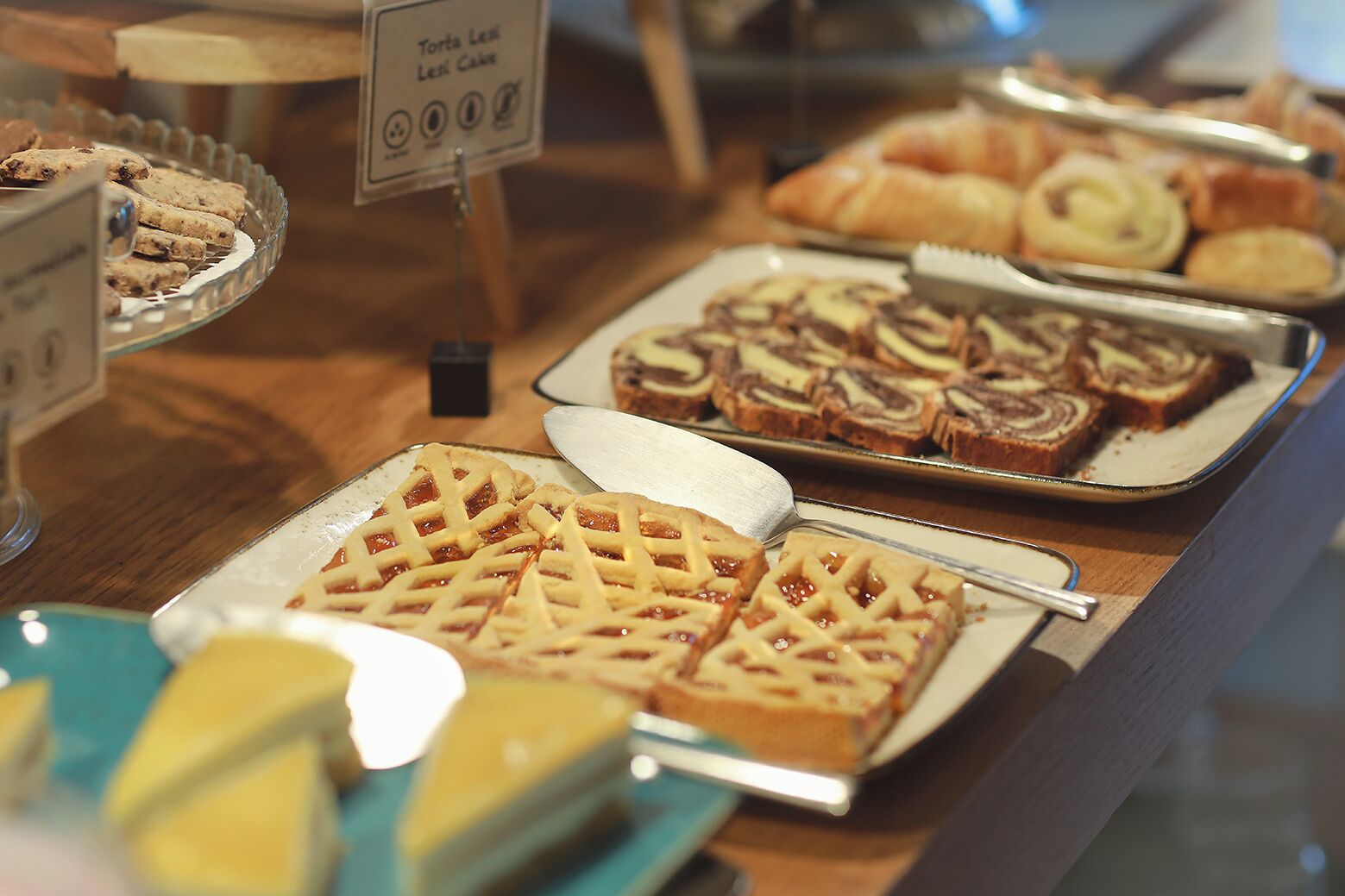 Un expositor de panadería con diversos pasteles y postres.