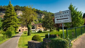 A sign for Hotel des Roches indicating parking and garden access. - Hôtel des Roches (Les Eyzies)
