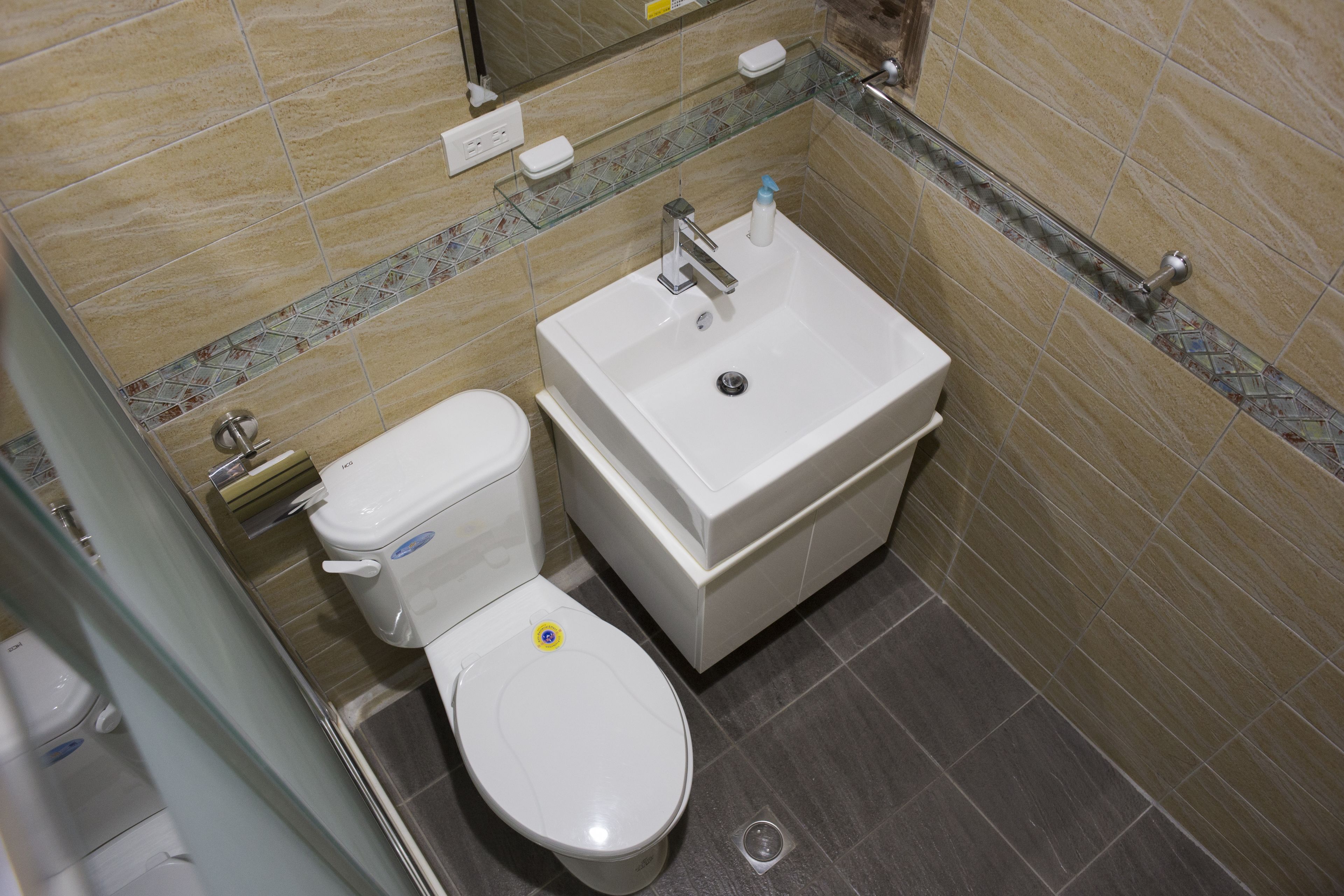 A bathroom with a toilet, sink, and shower area.