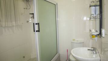 Un baño con ducha, inodoro y lavamanos.