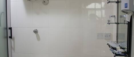 Een badkamer met een toilet, wastafel en een aan de muur bevestigde boiler.