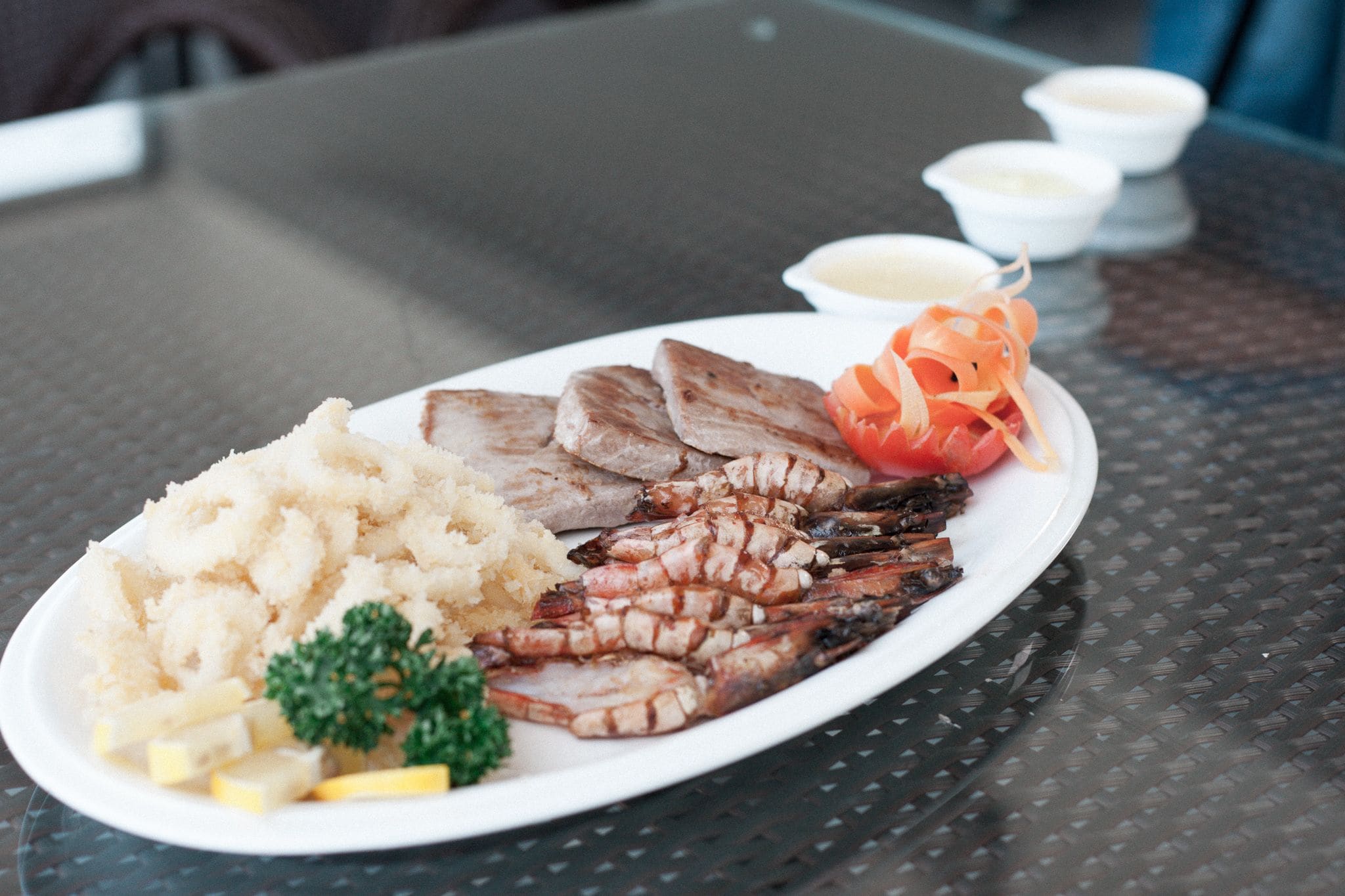 A plate of food with grilled meat, potatoes, and vegetables on a table.