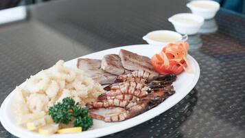 A plate of food with grilled meat, potatoes, and vegetables on a table.