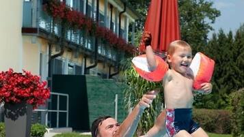 Relax by the pool surrounded by lush greenery and enjoy the scenic views from the balcony.