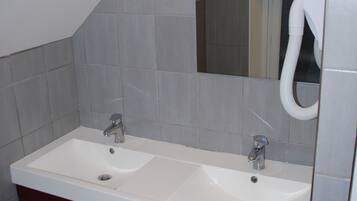 Un baño con dos lavamanos, un espejo y un perchero para toallas.
