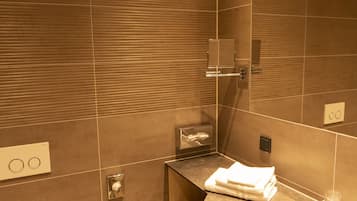 Un baño moderno con inodoro, lavamanos y espejo.