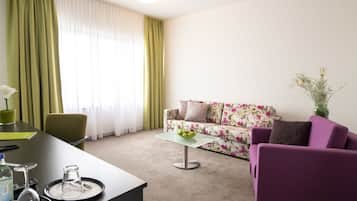 Uma sala de estar moderna com um sofá, uma mesa de centro e uma mesa de jantar com cadeiras.