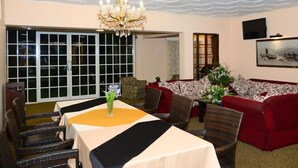 A dining area with a chandelier, a sofa set, and a TV mounted on the wall. - Country House - Nuwara Eliya (Nuwara Eliya)