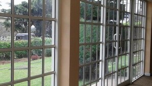 A corridor with large windows, beige walls, and patterned carpet. - Country House - Nuwara Eliya (Nuwara Eliya)