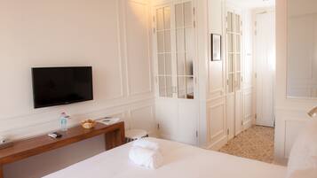 Una habitación de hotel con cama, televisión, escritorio y baño.