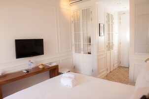 Una habitación de hotel con cama, televisión, escritorio y baño.
