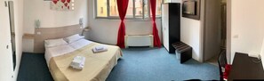 A hotel room with a bed, a desk, a chair, a TV, and a window with curtains. - Hotel Antonelli (Milan)
