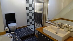 A modern bathroom with a white sink, a large mirror, a shower with a glass door, and a black and white checkered shower wall. - Hannover Guest House (Hannover)