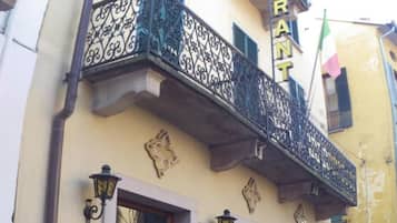 Un hotel con balcón, un cartel que dice 'Hotel Fiorentino' y una bandera.