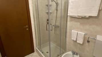 Une salle de bain dotée d’une douche à parois de verre, de toilettes, d’un bidet et d’une baignoire.