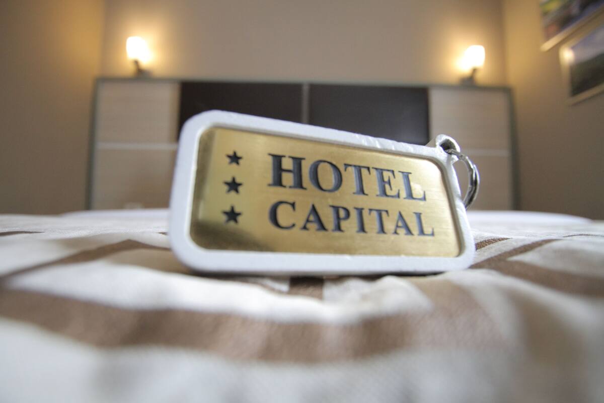 A keychain with the text "HOTEL CAPITAL" and three stars.