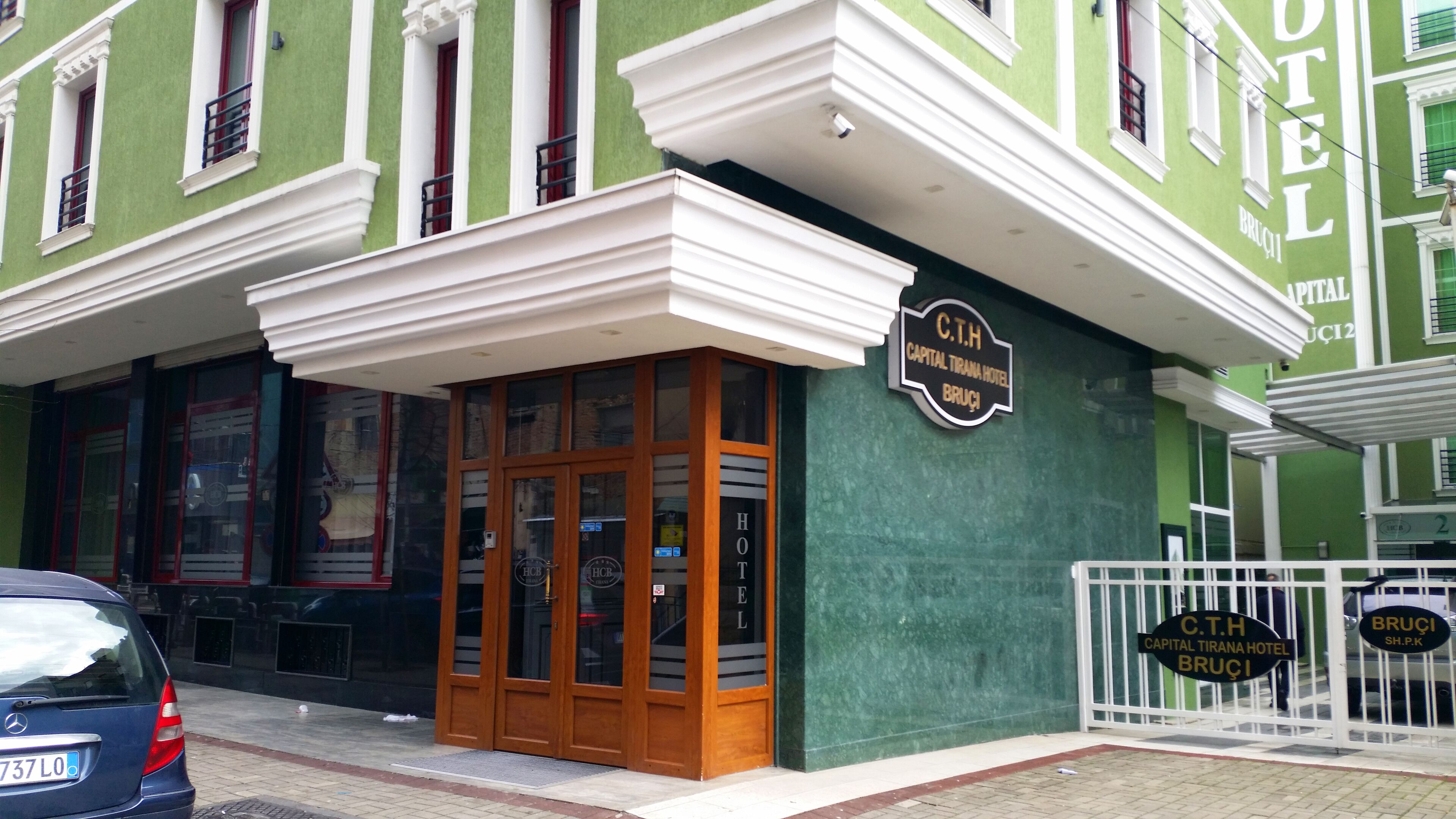 L’entrée d’un hôtel, avec une enseigne indiquant : « C.T.H. Capital Tirana Hotel ».
