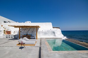 Un edificio bianco con piscina e area salotto esterna vista mare.